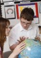 Child with autism and teacher looking at globe